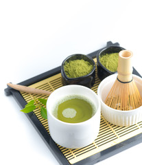 Wall Mural - Green matcha tea in a bowl and bamboo whiskon, isolated on white