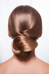 Back view of beautiful woman with creative elegant hairstyle, hair bun. Isolated on white background.