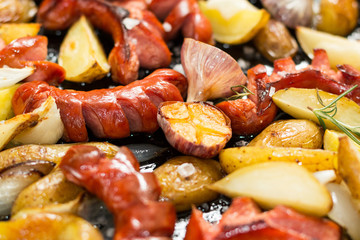 Wall Mural - Background of fried sausage with fried potatoes, selective focus.