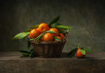 Still life with tangerines in a basket on the table