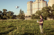 © scaliger - Man operating drone in city park in summer