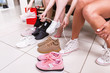 © undrey - Cropped image of teenage girls trying on sports shoes in a shop