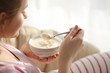 Bowl with yogurt and spoon in female hands