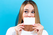 © Tierney - Woman holding a blank message card in front of her face