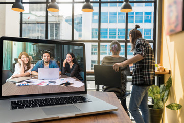 Computer laptop on the wooden table display Video conferencing With Colleagues and Hipster young couple freelancer when working in the Loft cafe workplace background, entrepreneur business concept