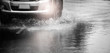 © chokchaipoo - Motion car runs through flood with water splash during hard rain fall.