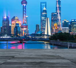 empty wooden platform with Shanghai skyline at night in background.