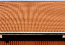 Red Tiles Roof With Rain Pipe And Corrugated Metal Wall.