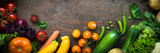 Organic farmer vegetables on dark slate table. Long banner format.