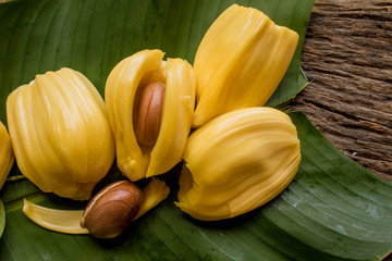 Wall Mural - pieces of sweet ripe Jackfruit and seed laying on green banana leaf, Tropical fruit. close up