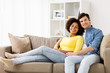 © Syda Productions - happy smiling international couple on sofa at home