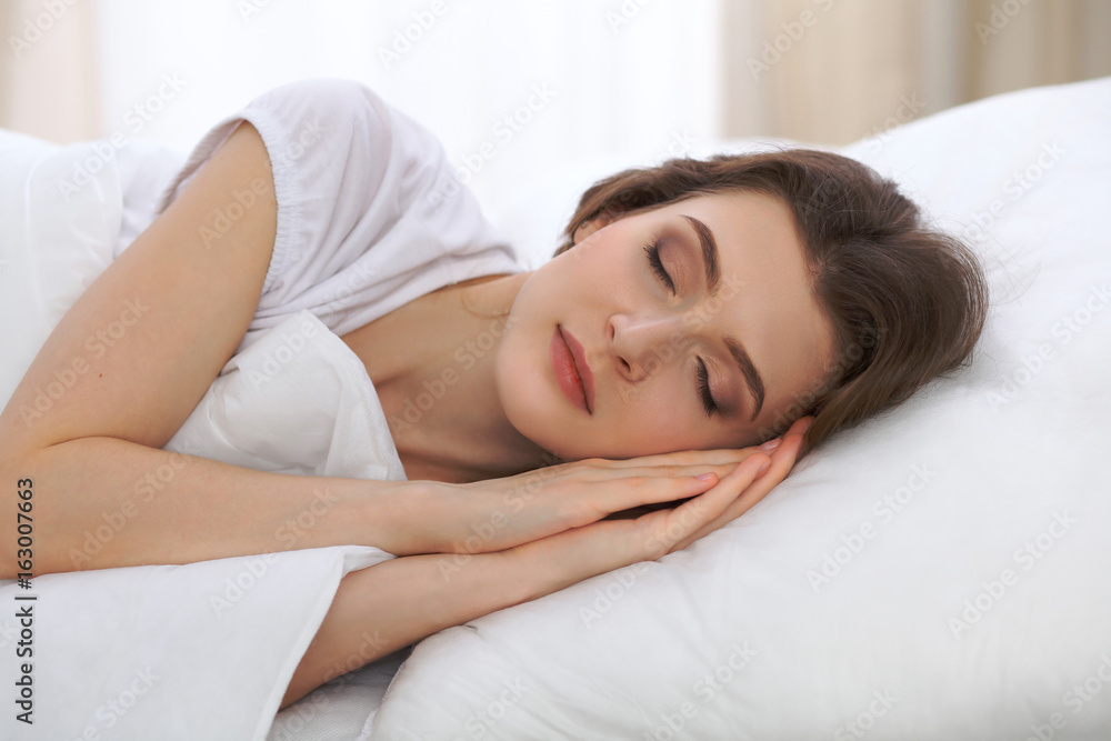 Beautiful young woman sleeping while lying in her bed and relaxing comfortably. It is easy to wake up for work or the day off. Concept of pleasant and rest reinstatement for active life - obrazy, fototapety, plakaty 