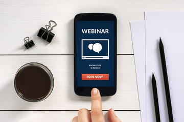 Wall Mural - webinar concept on smart phone screen with office objects on white wooden table. all screen content 