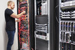 © kjekol - IT Consultant Working With Network Cables Connected To Servers