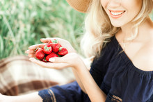 Smiling Girl Holding Strawberry In Hands Close Up Outdoors. Healthy Eating.