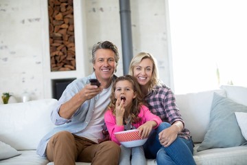 Wall Mural - Family watching television while having popcorn 