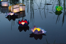 Water Burning Yellow Lanterns On The Lake Amid Tall Grass