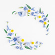 Flowers composition. Wreath made of blue and yellow flowers on white background. Flat lay, top view