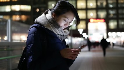 Wall Mural - Woman using cellphone at night