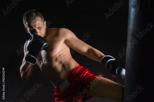 Foto The fighter of mixed martial arts beats the bag with his left foot