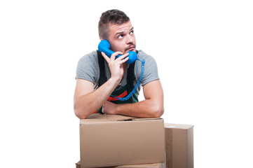 Mover man talking at phone with boxes around