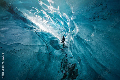 Fotografía Guy with crampons exploring gigantic ice cave in Iceland