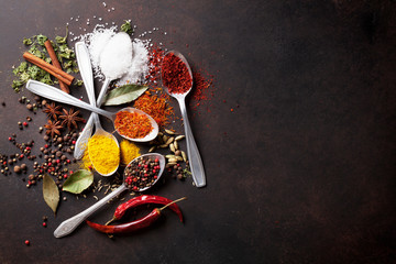 Various spices spoons on stone table