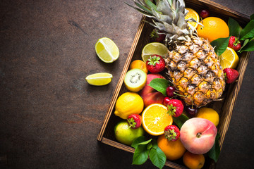 Fruit and berries over dark stone table.