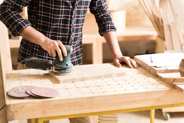 Carpenter is laboring with professional equipment