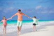 © travnikovstudio - Family of dad and kids having fun on the beach