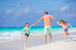© travnikovstudio - Family on white tropical beach have a lot of fun. Father and kids enjoy holidays on the seashore