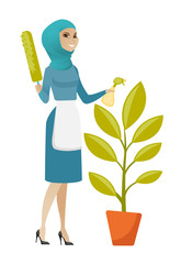 Wall Mural - Young muslim housemaid watering flower with spray.