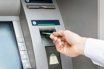 man hand insert credit card to atm