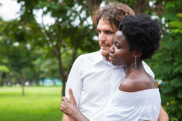 Contemplative couple looking forward and hugging