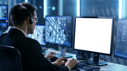 Wall Mural - Professional IT Engineers Working in System Control Center Full of Monitors and Servers. Possibly Government Agency Conducts Investigation. He Works With White Screen Isolated. Good for Template.