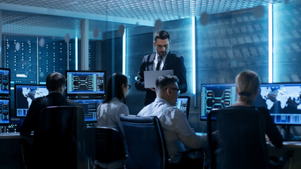 Aufkleber - Professional IT Engineers Working in System Control Center Full of Monitors and Servers. Supervisor Holds Laptop and Holds a Briefing. Possibly Government Agency Conducts Investigation.