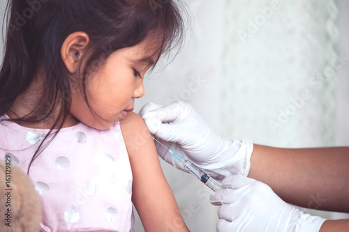 Pinturas sobre lienzo  Doctor injecting vaccination in arm of asian little child girl,healthy and medic