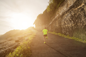 Wall Mural - Jogging / running up the hill at sunset / sunrise.