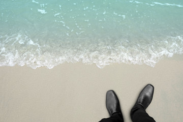 Businessman standing on the beach