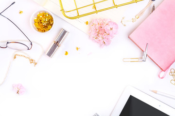 Workplace mockup with pink leather notebook, glasses, white tablet and golden accessories on white background top view. Flat lay with copy space.  Feminine working style concept.