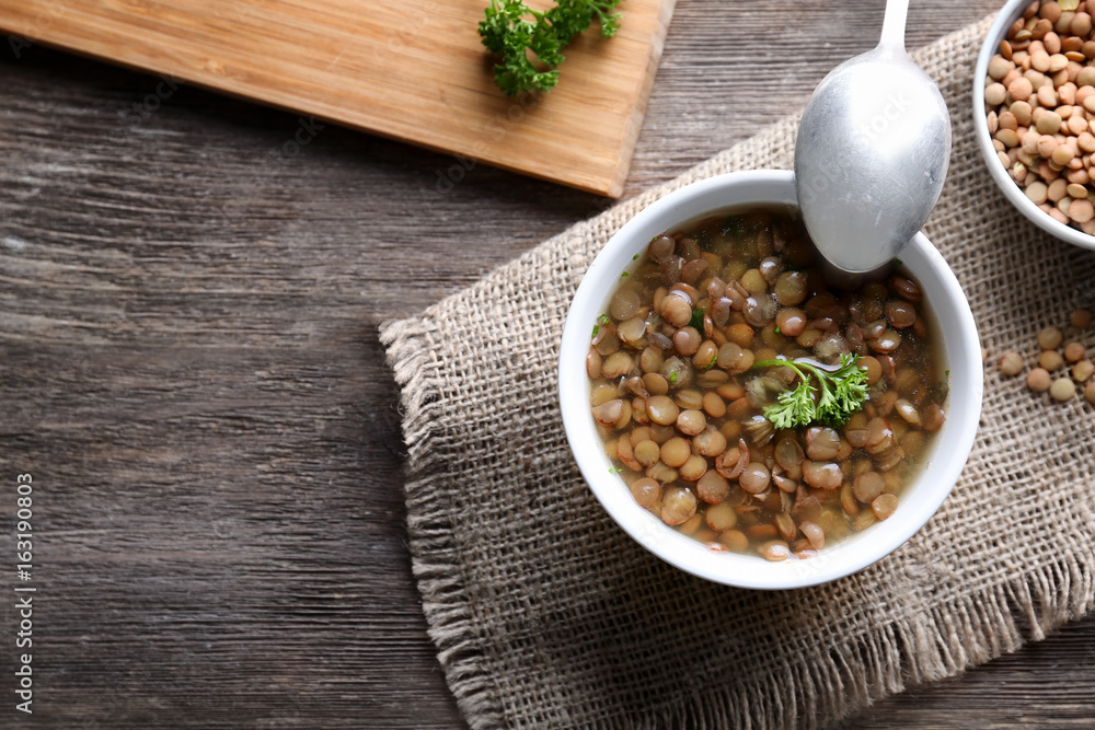 Composition with tasty lentil dish on wooden table