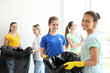 © Africa Studio - Young volunteers with garbage bags indoors