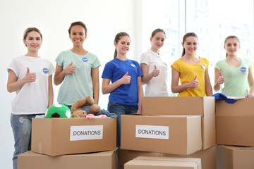 Sticker - Young volunteers with boxes of donations indoors