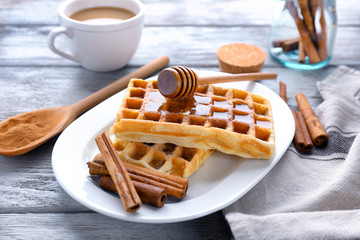 Wall Mural - Delicious cinnamon waffles with honey on table