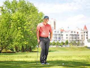 Canvas Print - Young man on golf course in sunny day