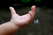 Children hand is playing with rain drops