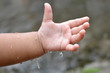 Child's hand is playing with rain drops