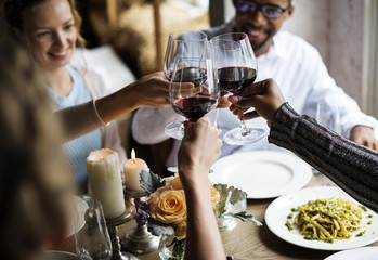 People Clinging Wine Glasses Together in Restaurant