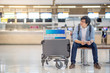© zephyr_p - young asian guy waiting for check in and drop his luggage at airline check-in counter of international airport terminal