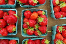 Strawberries Displayed In Baskets For Market On Wooden Table